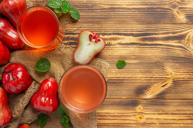 Rose apple juice on dark wooden surface