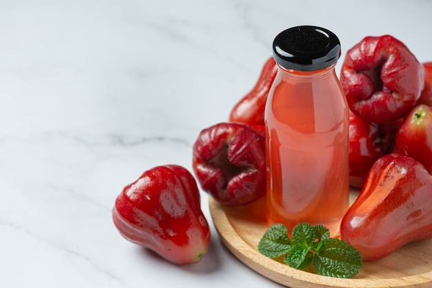 Rose apple juice on white surface