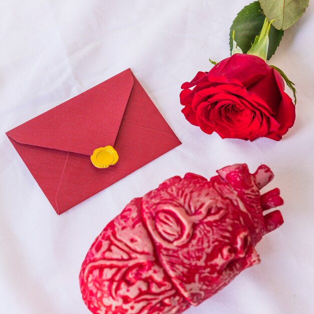 Rose branch with envelope on table 