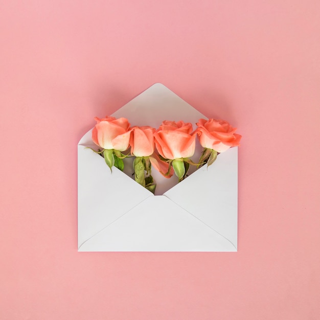 Rose flowers in envelope on table