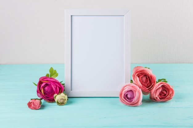 Rose flowers with blank frame on table