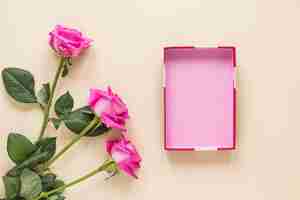 Free photo rose flowers with empty box on table