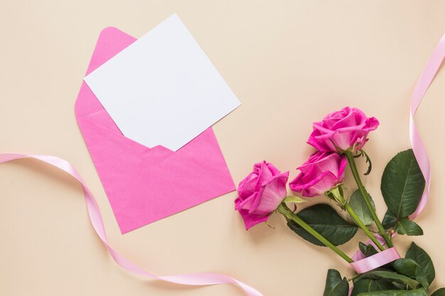 Rose flowers with paper in envelope