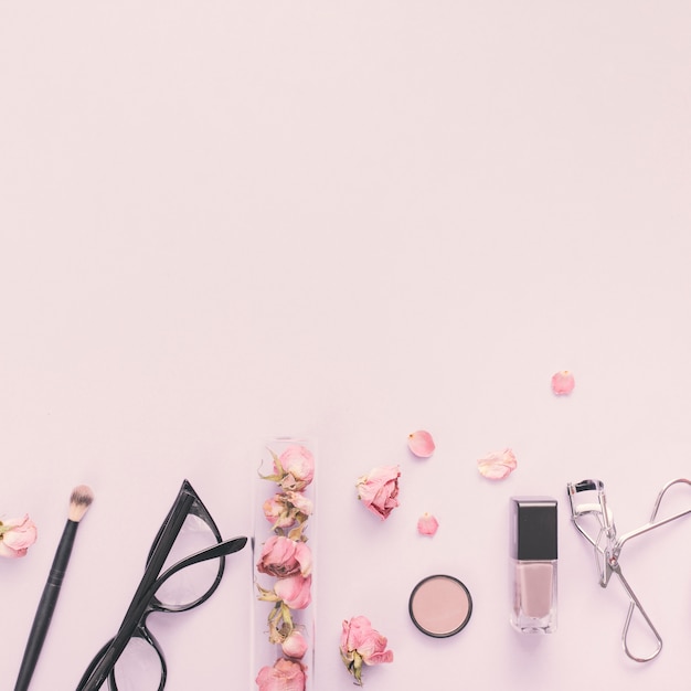 Rose petals with cosmetics on table