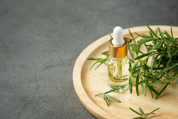 Rosemary oil in bottle with rosemary plants