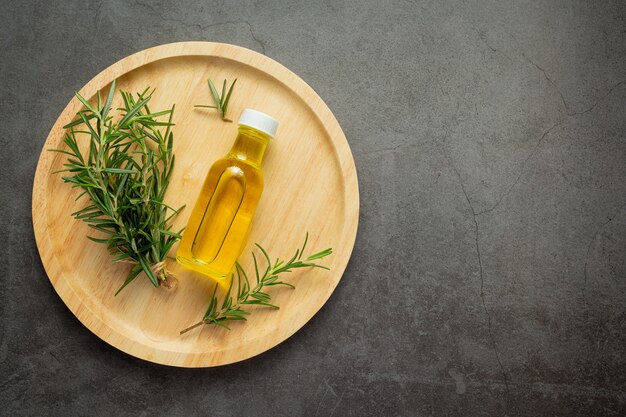 Rosemary oil in bottle with rosemary plants