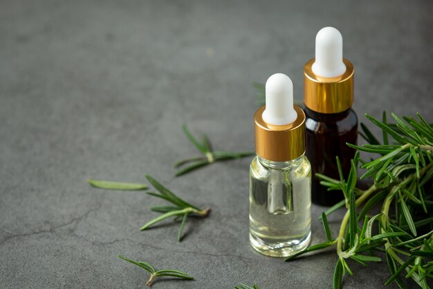 Rosemary oil in bottle with rosemary plants