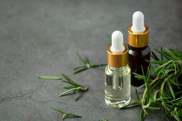 Rosemary oil in bottle with rosemary plants