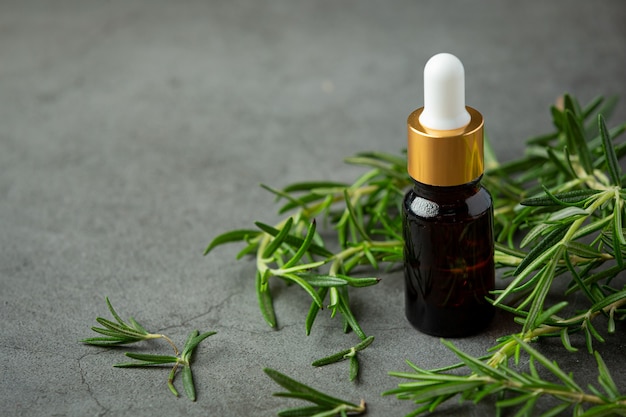 Rosemary oil in bottle with rosemary plants