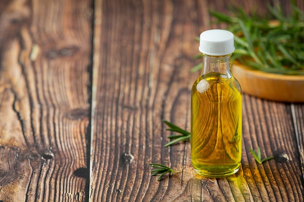 Rosemary oil in bottle with rosemary plants