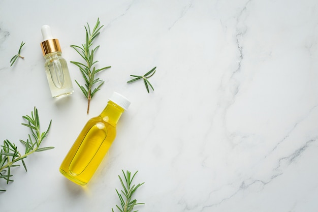 Rosemary oil in bottle with rosemary plants