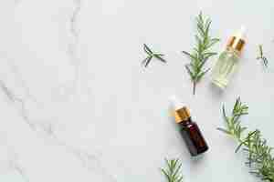 Free photo rosemary oil in bottle with rosemary plants