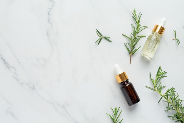 Rosemary oil in bottle with rosemary plants