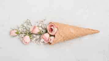 Free photo roses buds in ice cream cone flat lay
