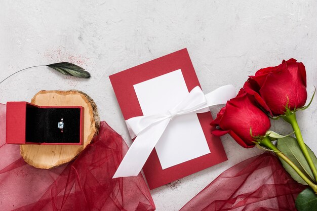 Roses and engagement ring on table