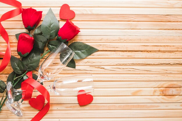 Roses and glasses on lumber background