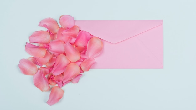 Roses petals with envelope on table