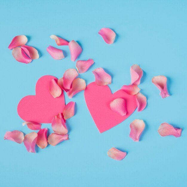 Roses petals with hearts on table 