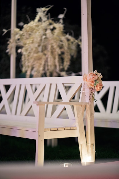 Free photo roses twined around bench which stands in the darkness