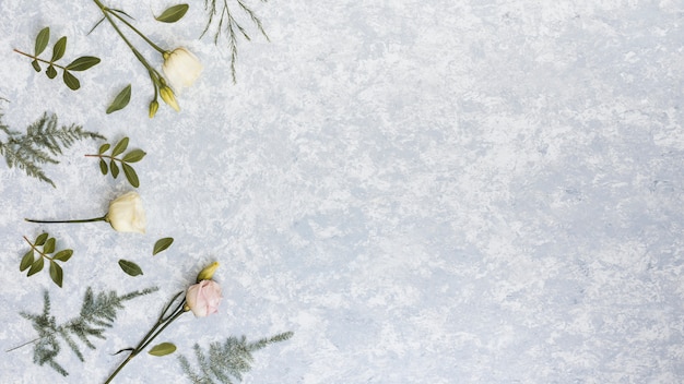 Free Photo roses with green plant branches on table