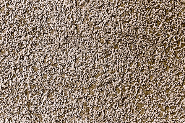 Free photo roughly gold painted concrete wall surface background