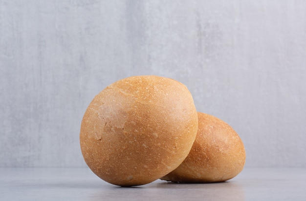 Round burger buns on stone surface