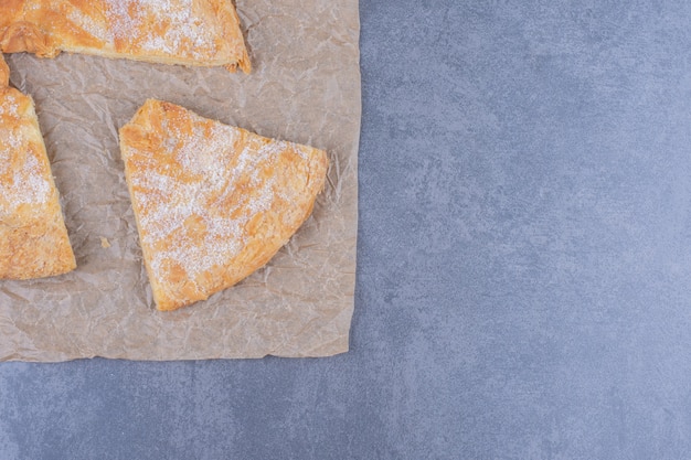 A round delicious pastry with sugar powder on a tablecloth