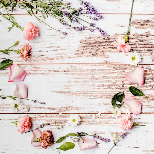 Round floral frame made over wooden background