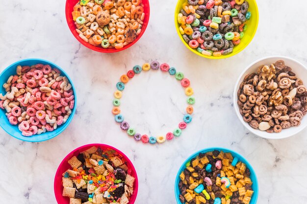 Round frame from cereals with different bowls on table