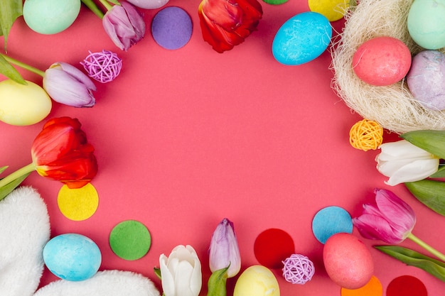 Round frame from Easter eggs and tulips on table