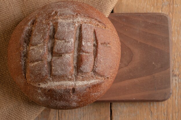 A round french rye bread on a wooden board.