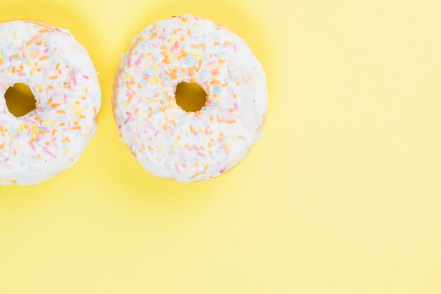 Round frosting doughnuts on yellow background