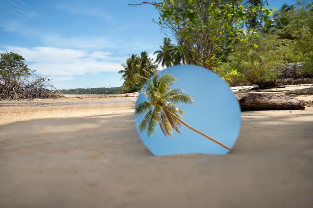 Round glass mirror at the beach reflecting landscape