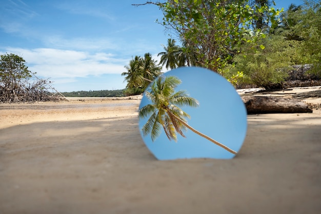 Round glass mirror at the beach reflecting landscape