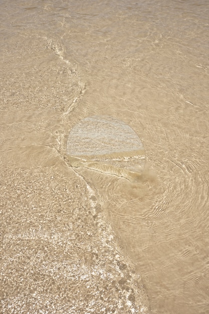 Round glass mirror at the beach reflecting landscape