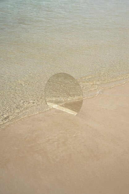 Round glass mirror at the beach reflecting landscape