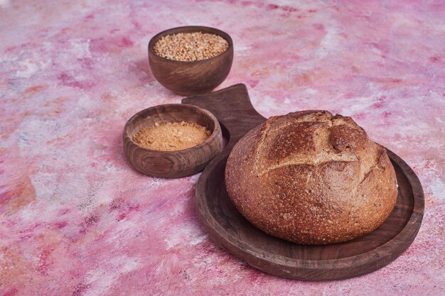 Round homemade bread with blended wheat aside.