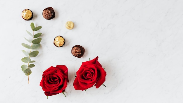 Free photo round nutty chocolates by a red rose wallpaper