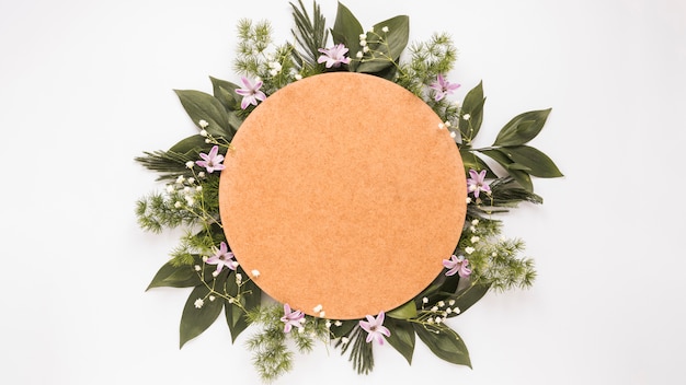 Round paper on green plant branches and flowers  