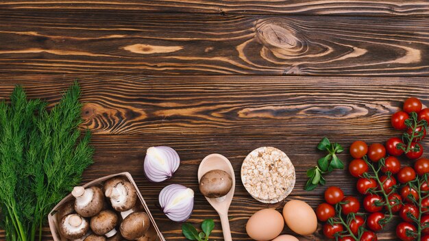 Round puffed rice cake with fresh vegetables on wooden textured