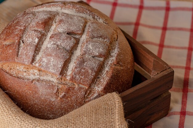 A round rye bread in a wooden tray.