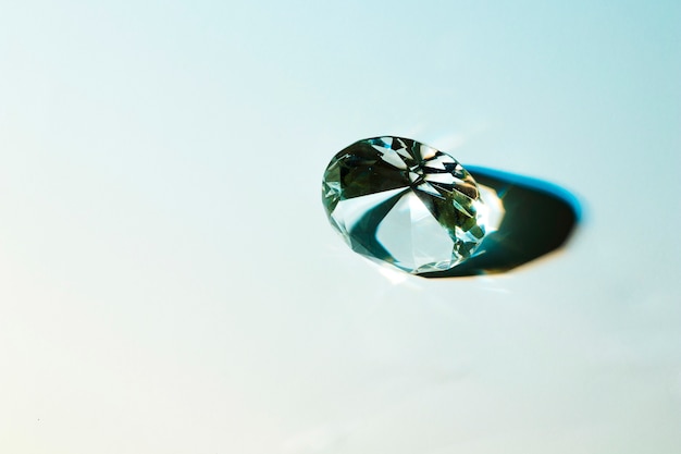 Round shiny diamond with shadow on colored background