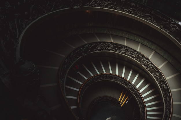 Round staircase in a Vatican museum leading visitors to look at Christian works of art