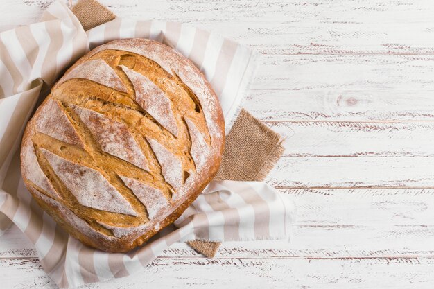 Круглый белый хлеб на ткани на кухне