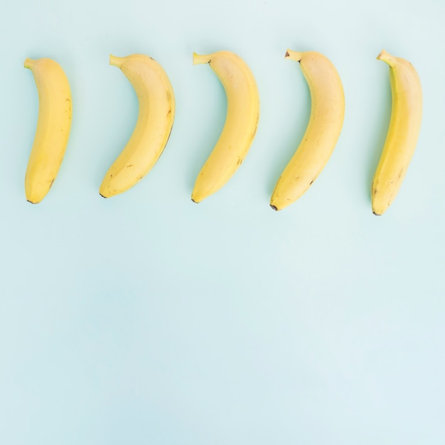 Row of bananas on blue