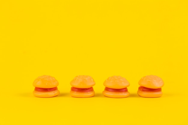 Row of burger candies on yellow backdrop