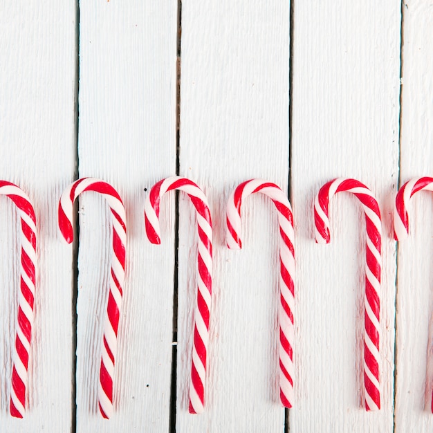 Free photo row of candy canes on wood desk