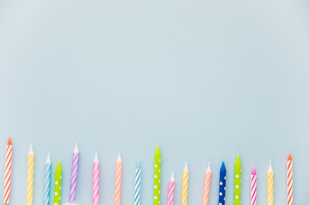 Row of colorful candles at the bottom of the blue background