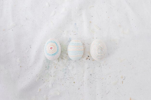 Row of Easter eggs with patterns and feathers on textile