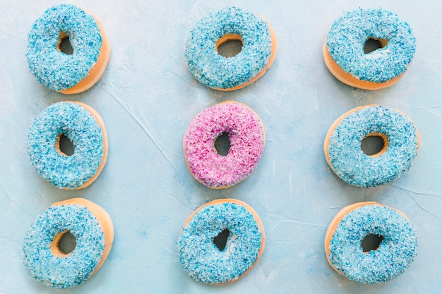 Row of fresh donuts on blue backdrop